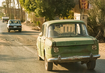 Old beaten car driving on Egypt streets