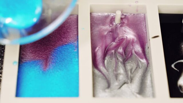 Mixing pink and blue epoxy resin in silicone mold on working surface, colours pigments with brilliant shades being mixed for creating exclusive natural pattern sample, innovative method of furniture