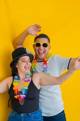 young latin couple, dancing while laughing loudly, he's behind her. yellow background
