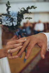 cropped view of bride putting on ring on her groom