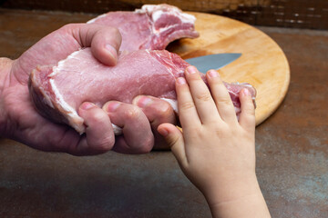 A man's hand is squeezing a piece of meat