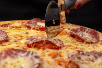 Slicing hot pizza with a round knife