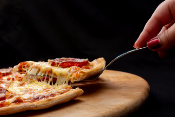 Melted cheese reaching for a slice of pizza