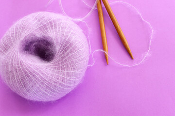 Purple cozy yarn ball of alpaca wool over violet background