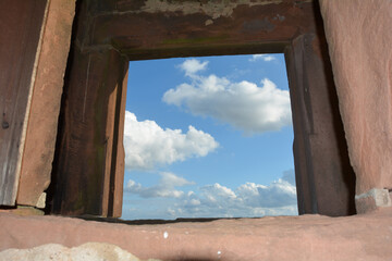 View through an old castle window on a blue sky