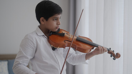 boy playing violin at home
