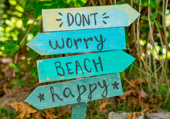 placa de madeira com as palavras don't, worry, beach, happy