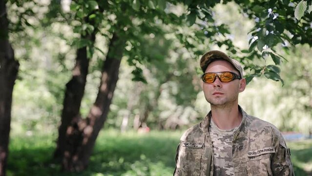 Man in military uniform walking in slow motion in the deep forest. Concept of military service, army, duty. Ukrainian armed forces