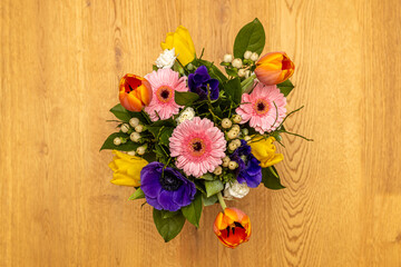 Bouquet with colorful flowers on wooden floor