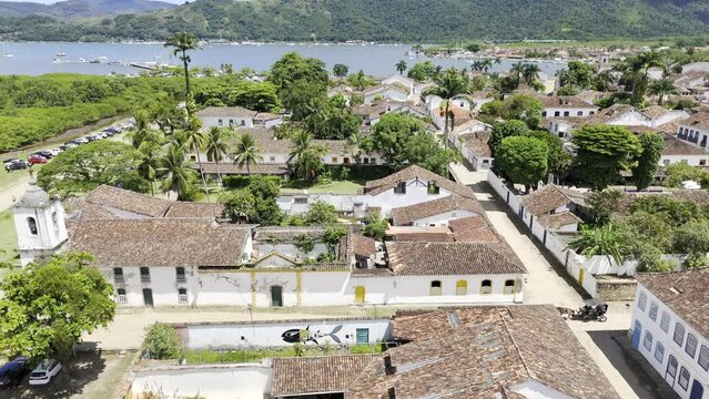 Aerial shot drone flies to the left over historic center of Paraty, facing the port
