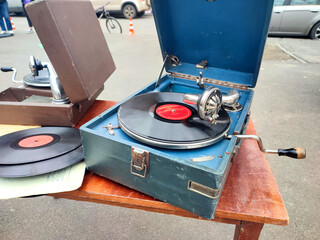 An old retro record playing on old vintage gramophone at flea market. Work of portable gramophone....