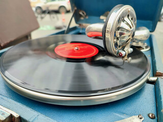 An old retro record playing on old vintage gramophone at flea market. Work of portable gramophone....