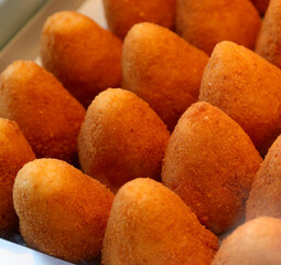 fried food called arancini ora ARANCINE in italian language filled with rice vegetables meat or cheese on sale at a market stall in Sicily southern Italy