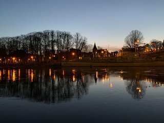 Fototapeta premium View of the city Tartu reflect in river Emajõgi during sunset, Tartumaa, Estonia, November 2019