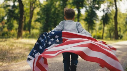Playful little boy waving United States flag and running in park, patriotism