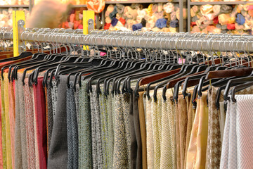 clothes fabrics and  pants neatly arranged on a clothing rack in a store