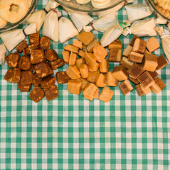 Table with typical sweets from Minas Gerais, Brazil. Sweet in corn husk, pe de moleque and milk fondant. Background with space for text.