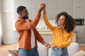 Cheerful married millennial spouses find joy in dance at home