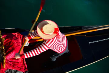 Deurstickers Venetian gondolier with hat and typical white and red dress while rowing on the gondola on the grand canal in Venice Italy © ChiccoDodiFC