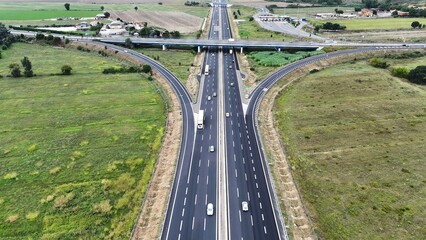 An overhead perspective of a highway featuring two lanes for vehicles to travel. The road stretches into the distance, with cars and trucks moving in different directions.