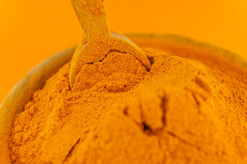 ground turmeric on orange background