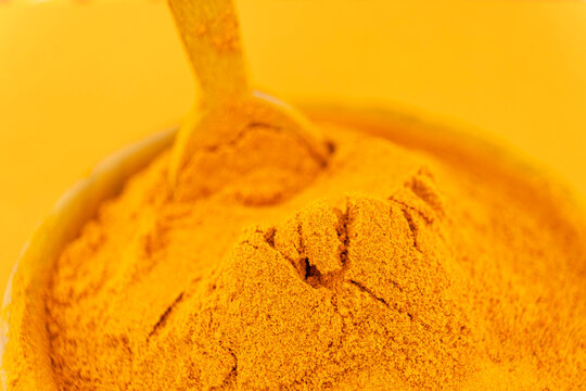 ground turmeric on orange background