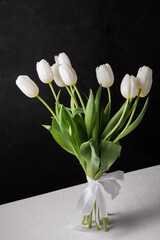 A bouquet of white tulips on a black background