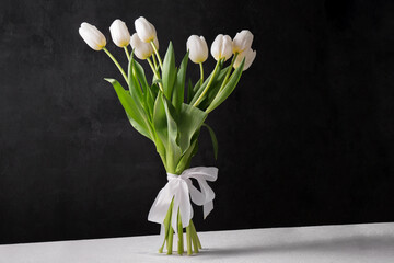 A bouquet of white tulips on a black background