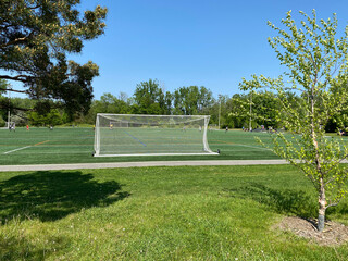Soccer goal on a field. Football net in a stadium. Green lawn of a sports court, in a park.