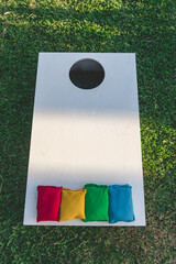 Cornhole (sack toss, or bags) is a lawn game popular in North America in which players or teams take turns throwing fabric bean bags at a raised, angled board with a hole in its far end