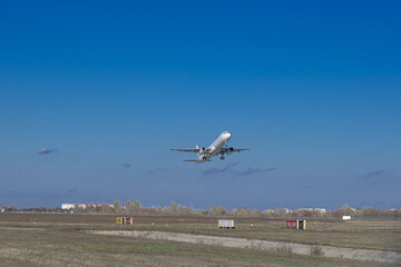 Airplane taking off from the airport. White Passenger plane fly up over runway from airport. Commercial passenger airplane takes off from the runway.