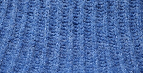 Texture of soft blue knitted fabric as background, closeup