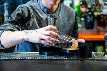 Camarera de cocktail bar prepara bloody Mary sobre una barra de un cocktail bar exclusivo en ambiente nocturno con detalle sobre el cocktail exquisito