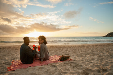 Smiling young multiethnic couple enjoying a sunset at the beach