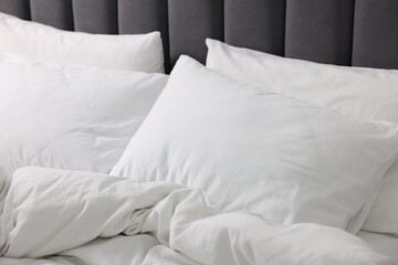 Fototapeta na wymiar Soft white pillows and duvet on bed