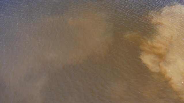 Muddy river with brown water. Spring flood. Dirty muddy water during flooding during heavy spring rains. Pollution of nature