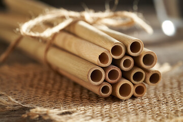 A bundle of bamboo straws on a table. Ecological zero-waste drinking straws.