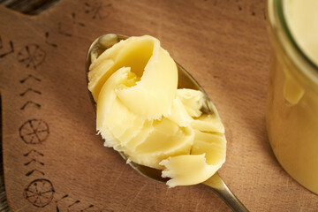 Ghee or clarified butter on a spoon on a table
