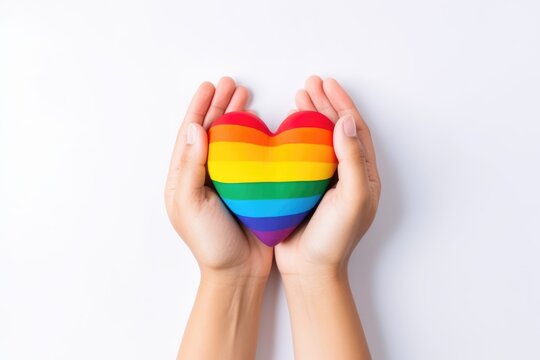Hands cradling a rainbow heart symbolizing LGBTQ pride. Hands Holding Multicolor Heart