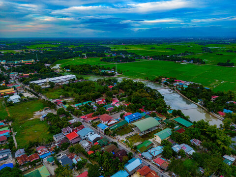 Cloudy Skies Above a Flourishing Township Amidst Green Fields in Bulacan, Philippines