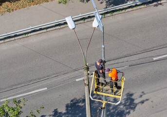 Workers installing a new street lamp.