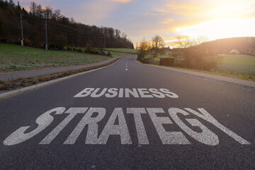Business strategy written on highway road in the middle of empty asphalt road at beautiful blue sky. Business strategy concept new company.