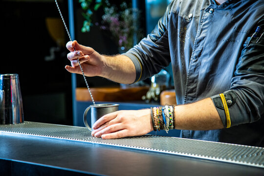 Barman prepara cocktail de pi&ntilde;a colada sobre la barra de un cocktail bar nocturno close up con detalles exclusivos