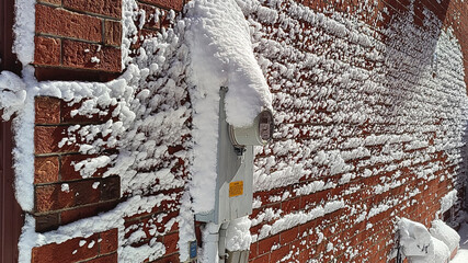 The exterior wall of a house after a heavy snow storm.