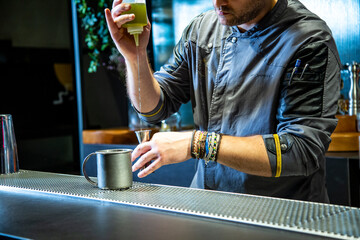 Barman prepara cocktail de piña colada sobre la barra de un cocktail bar nocturno close up con detalles exclusivos