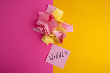 Lottery ticket with the word winner on a colored background near sheets of paper. Winner concept
