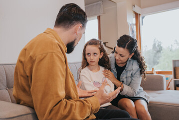 Mother hugging her daughter while her father is talking