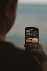 hand holding a phone on golden hour