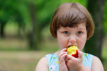 Happy little girl playing under fruit trees