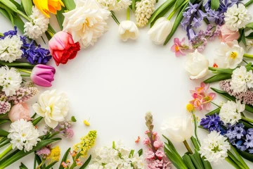 Fototapeten Spring flowers frame made of tulips, daffodils, crocuses, hyacinths, lilacs, cherry blossoms, azaleas on white background. Top view, flat lay, copy space in middle © vejaa